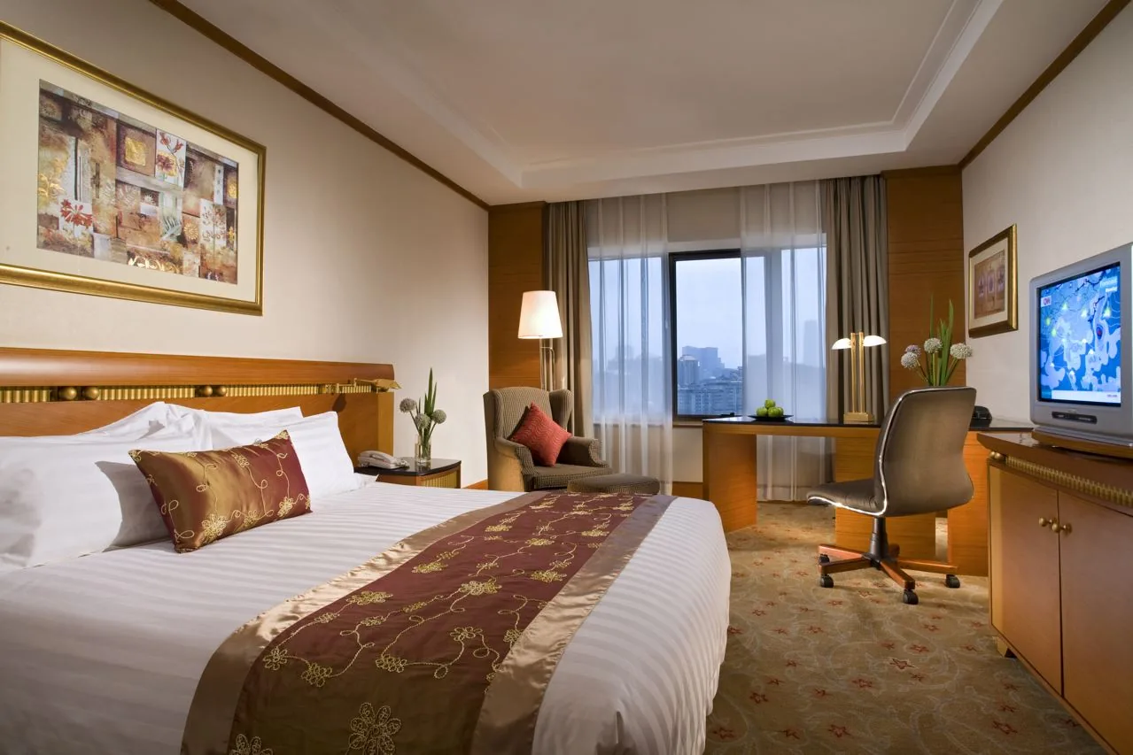 Hotel guest room with bed linen and full-height drapery